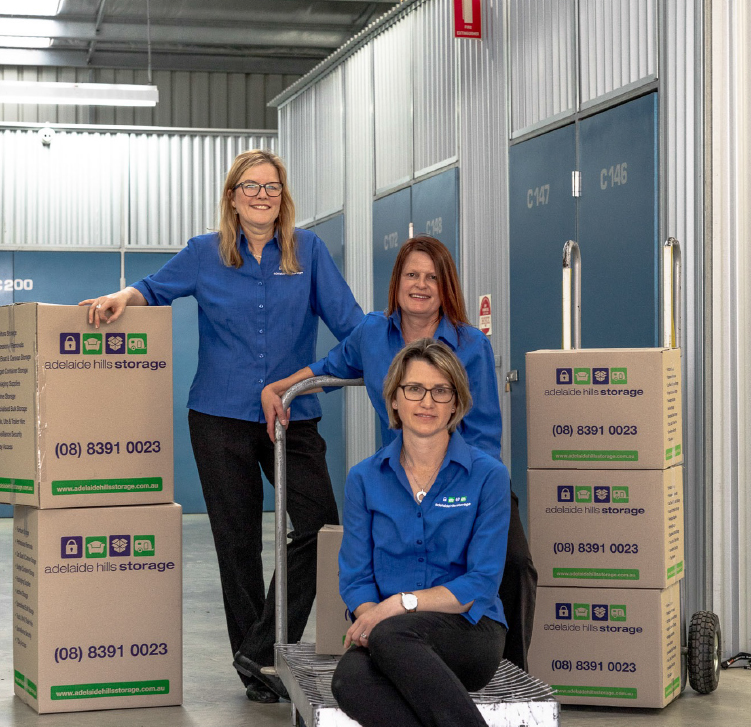 Three females in front of internal storage units