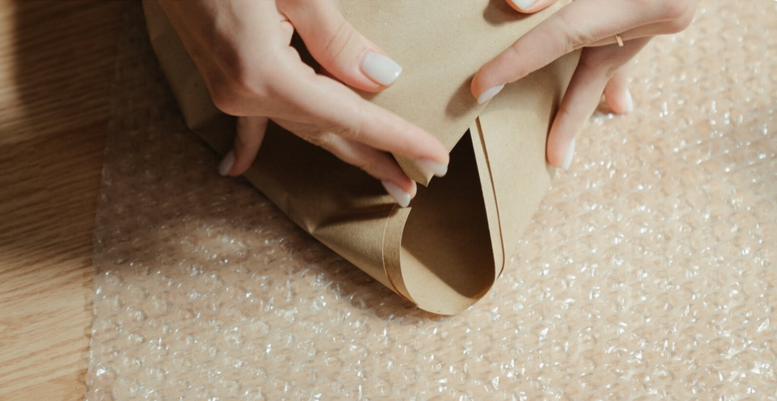Woman folding packing paper on top of bubble wrap