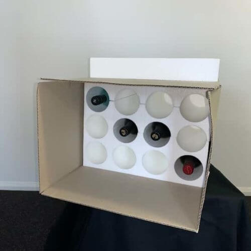 Storage box holding wine bottles and polystyrene padding